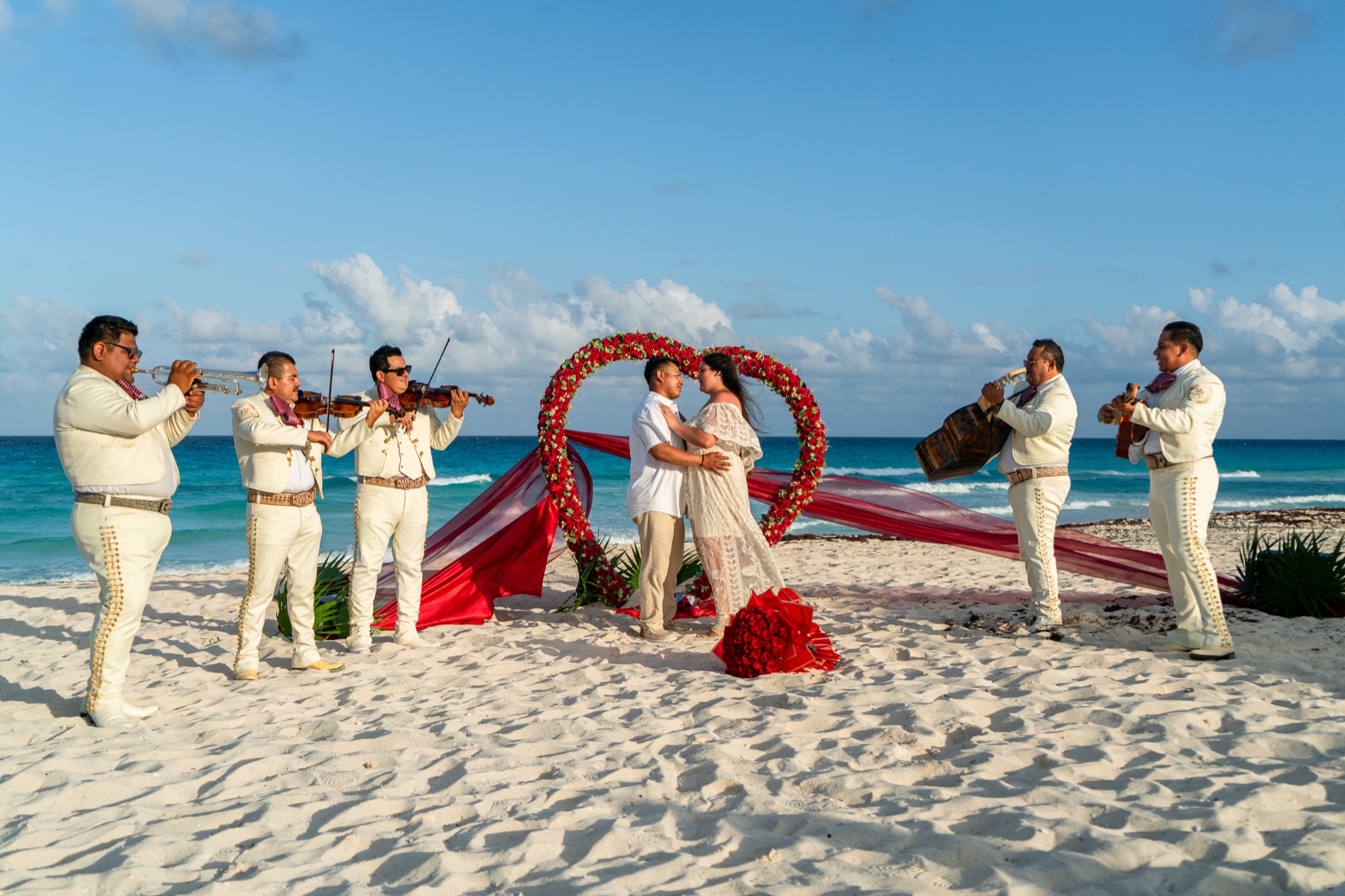 Pareja rodeada por mariachi y un corazón de rosas en Cancún