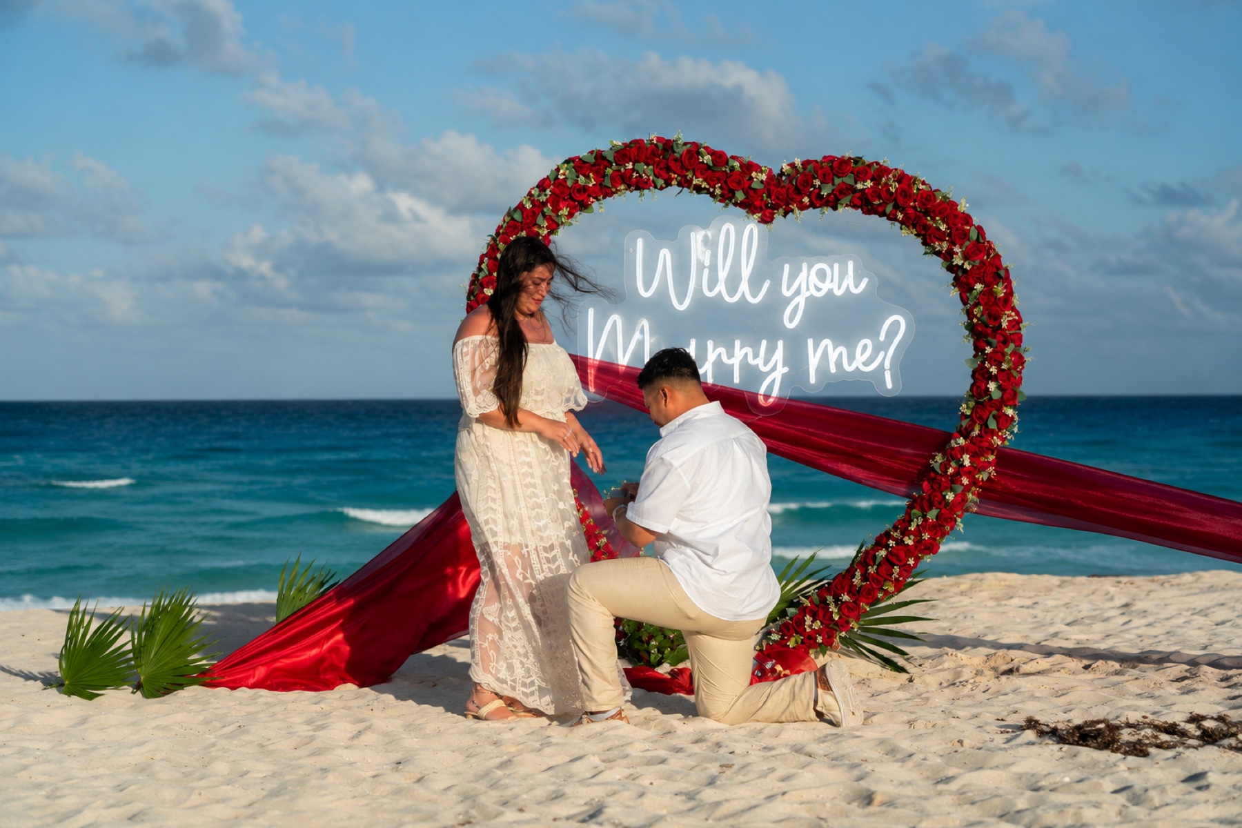 Pedida de matrimonio frente al mar con arco de rosas