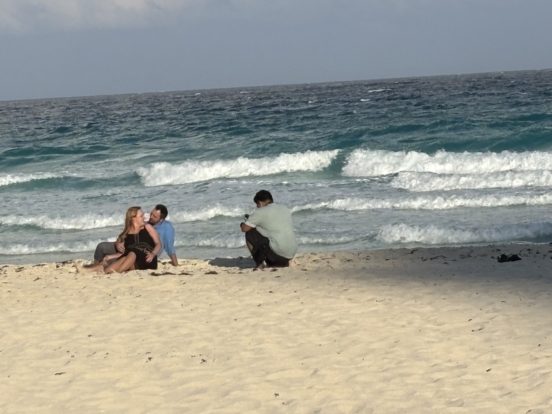 Couple and photographer by the sea after the surprise